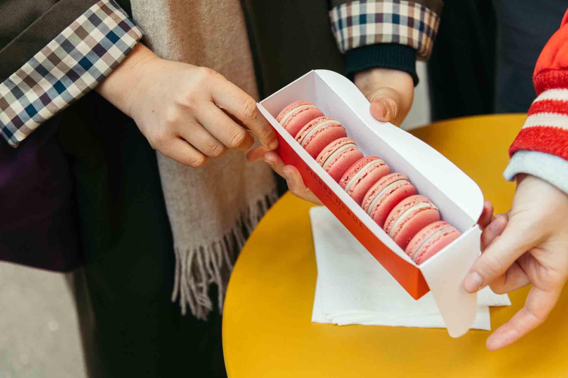 person_holding_a_pink_container_of_macarons_Pierre_Hermé_Paris