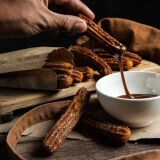Person_dipping_churros_into_sauce_Barcelona